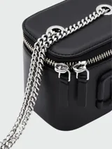 Mini cartera tipo vanity de cuero negro con cierre superior y logo de la marca en relieve. Incluye una correa de cadena metálica plateada para llevar cruzada.