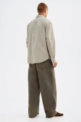 Camisa de popelina de algodón con cuello inglés, tapeta clásica y bolsillo superior abierto. Presenta un canesú en la espalda y mangas largas con puños abotonados. El bajo es levemente redondeado.