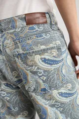 Jean recto de tiro medio con estampado paisley en tonos azules, beige y blanco.