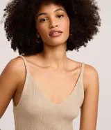 Musculosa de punto canelado color beige con hilo metalizado, escote en V y tirantes finos.