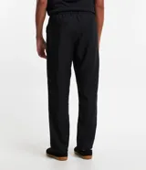 Pantalón de sastrería corte loose, color negro, con cintura con trabillas, cierre de botón y cremallera, y bolsillos laterales tipo cuchillo.