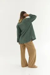 Camisa blanca de algodón con botones marrones, corte holgado y mangas largas.