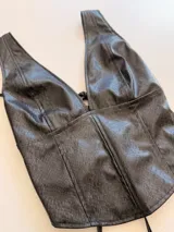 Top sin mangas de ecocuero con textura efecto reptil, escote en V profundo y corte entallado.