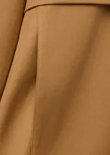 Chaqueta oversize color tostado con cuello embudo, manga larga, bolsillos laterales y bolsillos de parche con solapa. Cuenta con cierre delantero de cremallera y botones ocultos bajo tapeta, y forro interior.