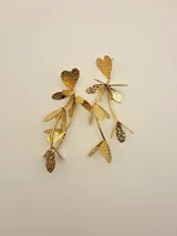 Aros colgantes dorados con forma de corazón y hojas.