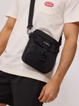 Bandolera negra de nylon con correa ajustable y logo Rusty estampado en blanco.