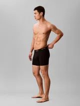Pack de tres bóxers Calvin Klein de corte brief, color negro, con cintura elástica distintiva de la marca en negro y letras verdes. Confeccionados en algodón elástico para un ajuste cómodo.