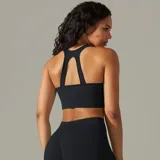 Top deportivo color beige, de tejido acanalado, con espalda deportiva y abertura en forma de gota.