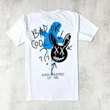 Remera blanca de mangas cortas con estampa en la espalda de un conejo negro con ojos en forma de cruz, una cruz celeste y la frase "Bad or Cool".