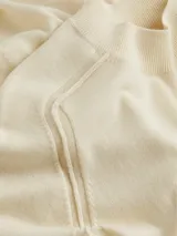 Vestido midi de lana merino color crema, con cuello alto y mangas cortas.