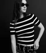 Blusa de punto ligero con diseño de rayas horizontales, cuello redondo y mangas cortas. Confeccionada en una mezcla de viscosa y poliamida, presenta un ajuste al cuerpo.