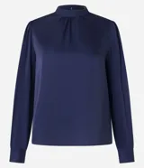 Blusa azul marino de tejido satinado con cuello alto, mangas largas y puños ajustados con botón.