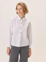 Camisa de corte femenino y sofisticado, con cuello redondo, manga larga y cierre frontal de botones. Confeccionada 100% en algodón.