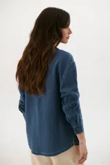 Sobrecamisa azul con cuello clásico, cierre frontal con botones y bolsillos de parche en el pecho.