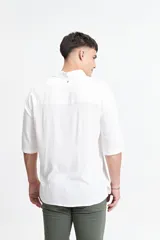 Camisa blanca de manga corta, corte oversize y cuello clásico.
