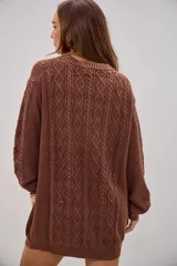 Sweater de punto color marrón chocolate, con diseño de trenzas y rombos en el frente, cuello redondo y mangas largas con puños acanalados.