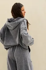 Campera oversize de felpa con efecto acid wash gris, capucha ajustable, cierre frontal de cremallera y mangas largas caídas.