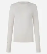 Suéter ajustado de punto color crema, con cuello redondo y mangas largas con botones metálicos en los puños. Confeccionado con viscosa sostenible.