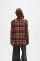 Blazer de corte holgado con diseño a cuadros en tonos marrones y negros. Presenta cuello con solapa, cierre frontal con un botón y bolsillos laterales con solapa.