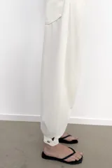 Jeans negro de tiro medio con corte balloon fit, diseño de cinco bolsillos y bajo acabado en puño con abertura y botón.
