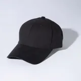 Gorra negra de gabardina con diseño de seis paños, ojalillos bordados para ventilación y visera curvada con costuras pespunteadas.