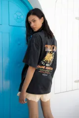 Remera oversize unisex de color negro con efecto gastado. Presenta una estampa trasera con un sol, la frase "Sabor Oriental" y "Hecho en Uruguay".