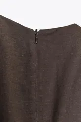 Vestido midi marrón sin mangas confeccionado en hilatura con 10% de lino. Tiene cuello redondo, corte evasé y cierre trasero con cremallera oculta.