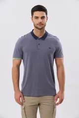 Remera polo de manga corta en color índigo con cuello y botones en contraste. Presenta detalles de color en los puños, aportando un toque sutil y moderno.
