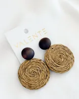 Aros colgantes con base circular de madera color marrón oscuro y dije circular de paja trenzada.