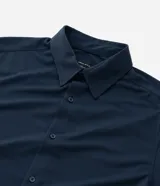 Camisa masculina de manga larga, cuello inglés y cierre frontal de botones, confeccionada en poliamida con elastano y tecnología performance.