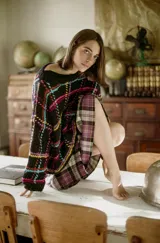 Sweater de lana tejido a mano con diseño geométrico multicolor sobre fondo negro, de calce holgado, cuello redondo y puños ajustados.