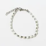Pulsera elástica con cuentas plateadas y blancas.