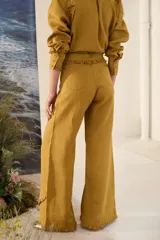 Pantalón morado de corte acampanado con volados decorativos en la cintura y en el ruedo.