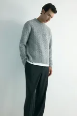 Pantalón de corte relajado y pierna recta, confeccionado en tejido suave de color negro. Presenta cintura elástica con cordón de ajuste, pliegues frontales y traseros, bolsillos laterales discretos y un bolsillo posterior insertado.