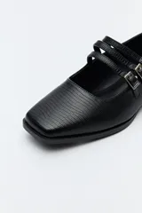 Zapato tipo Mary Jane de charol sintético color rojo, con punta cuadrada y triple tira con hebillas.