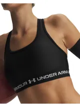 Top deportivo Under Armour modelo Crossback Mid, color negro, confeccionado en tejido HeatGear de doble capa con soporte estratégico para actividades de impacto medio. Cuenta con banda elástica inferior con el logotipo de la marca impreso en blanco.