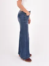 Jean de tiro alto con corte wide leg, confeccionado en denim azul con efecto lavado y costuras en contraste. Presenta diseño de cinco bolsillos y ruedo con doble costura.