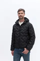 Campera de nylon matelaseada con capucha integrada, cierre frontal y diseño de costuras geométricas. Presenta un ajuste regular y es ideal para climas fríos.