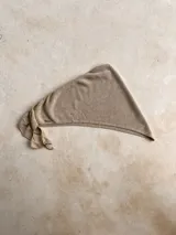 Bandana o turbante de punto fino color beige claro, con textura brillante o metalizada.