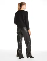 Cardigan de punto con textura tipo waffle, color blanco, con escote a la base, cierre frontal con botones metálicos dorados y detalles desflecados en la tapeta y los bolsillos simulados.