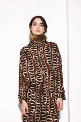 Pantalón de vestir marrón con estampado abstracto en negro y blanco.