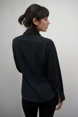 Camisa de manga larga con calce entallado y cartera frontal oculta. Presenta un diseño de superficie lisa con caída suave que se ajusta a la silueta.