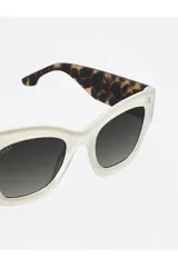 Lentes de sol Tiwi modelo Mayfair, con montura color beige brillante y lentes con degradado verde.