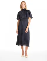 Vestido midi de satén color azul marino, con cuello alto y cintura elástica, ambos con detalle en punto smock. Presenta mangas cortas fluidas y falda plisada con caída ligera.