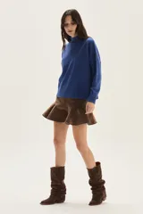 Polera de tejido de punto color azul, con cuello alto, manga larga y puños acanalados.