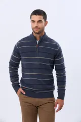 Buzo de algodón tejido color azul marino con rayas horizontales en beige y bordó. Presenta cuello alto con medio cierre frontal y puños y dobladillo acanalados.