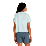 Remera deportiva de mujer New Balance, color celeste claro, con cuello redondo, mangas cortas y logo de la marca estampado en el pecho.