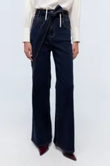 Jean de tiro alto color azul oscuro, con pierna levemente acampanada y cinturón con triple pespunte.