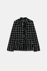 Chaqueta Zara Woman Collection de corte recto, confeccionada en tejido de mezcla de algodón con diseño de cuadros. Presenta cuello redondo, cierre frontal con botones, bolsillos de plastrón en el delantero y detalle de flecos en los bordes, puños y solapa frontal. Incluye forro interior.