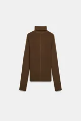Jersey de punto confeccionado en lana, con cuello subido y manga larga. Presenta un diseño ajustado con detalle de costuras marcadas en el frente.